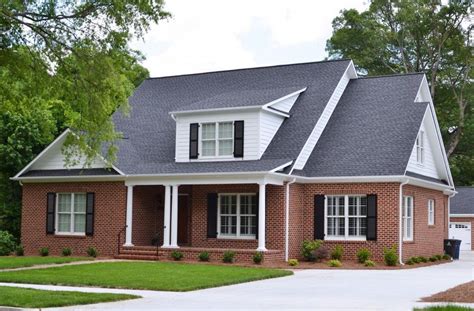 red brick house with black metal roof|brick homes with metal roofs.